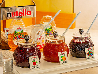 Konfitüren- und Honigauswahl am Frühstücksbuffet Konfitüren und Honiggläser mit Etiketten auf dem Frühstücksbuffet