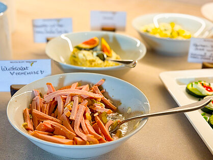 Hausgemachter Wurstsalat und Feinkostsalate am Frühstücksbuffet Hausgemachter Wurstsalat mit Gurken in einer weißen Schale am Buffet