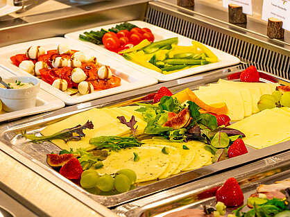 Käse- und Gemüseauswahl am Frühstücksbuffet Käseplatte mit Obstgarnitur und frischem Gemüse am Frühstücksbuffet