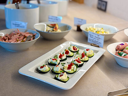 Herzhafte Häppchen und Salate am Frühstücksbuffet Gurkenscheiben mit Frischkäse und Paprika sowie hausgemachte Salate auf dem Frühstücksbuffet
