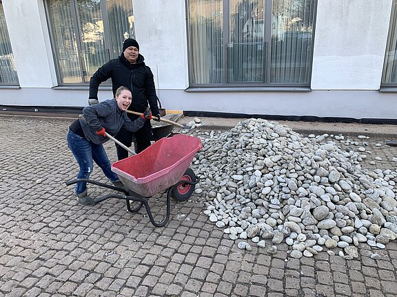 Sarah Spahn und Chaowalit Naboon helfen mit dem Kies Sarah Spahn und Chaowalit Naboon helfen mit dem Kies