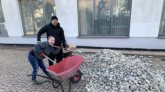 Sarah Spahn und Chaowalit Naboon helfen mit dem Kies Sarah Spahn und Chaowalit Naboon helfen mit dem Kies