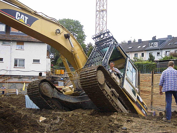 22 Tonnen Bagger CAT 320B L Der 22 Tonnen schwere Bagger “CAT 320B L” zieht sich aus der Baugrube